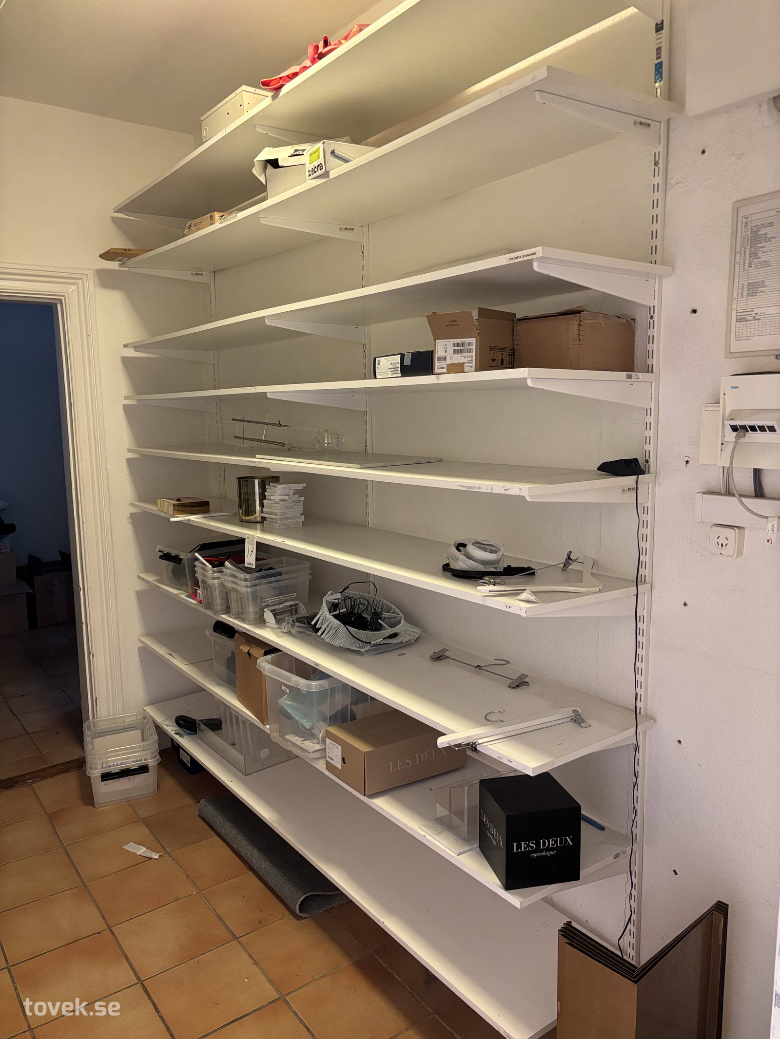 Konsollhylla med innehåll ca 248x230cm på auktion i Halmstad hos Toveks Auktioner