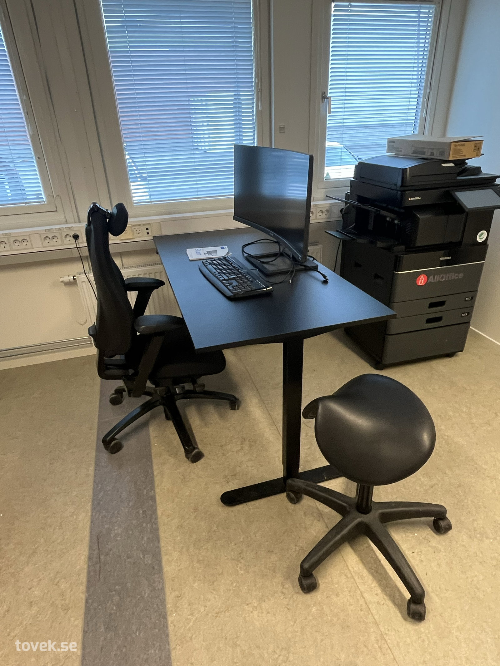 Kontorsplats: Höj- och sänkbart skrivbord med Philips bildskärm, tangentbord, kontorsstol och sadelstol